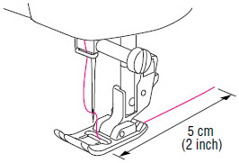 Führen Sie das Fadenende durch den Nähfuß und ziehen Sie dann ca. 5 cm (2 Zoll) Faden heraus.